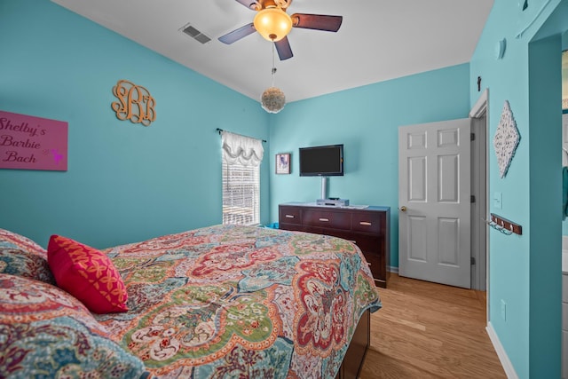 bedroom featuring visible vents, light wood-style flooring, baseboards, and ceiling fan