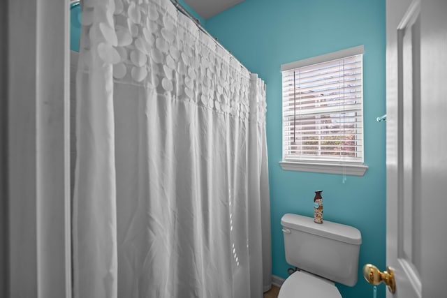 bathroom featuring curtained shower and toilet