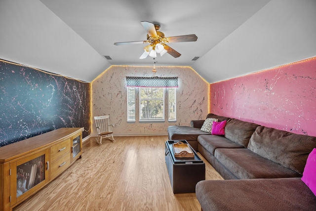 living area with vaulted ceiling, wood finished floors, visible vents, and ceiling fan