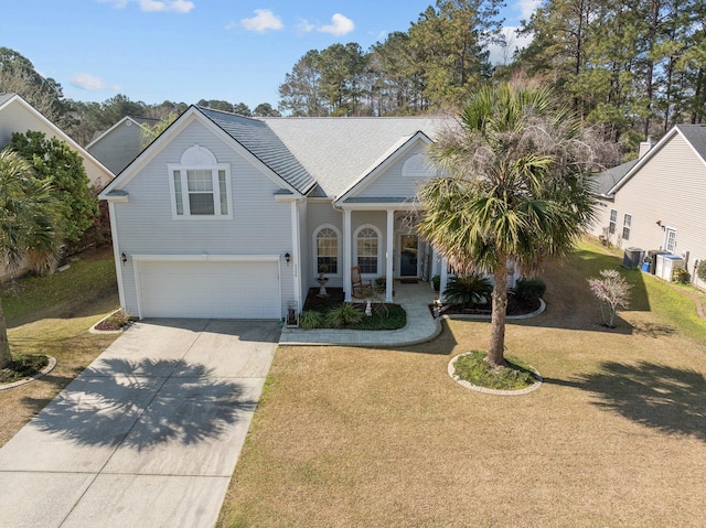 traditional home with a porch, a garage, driveway, and a front yard