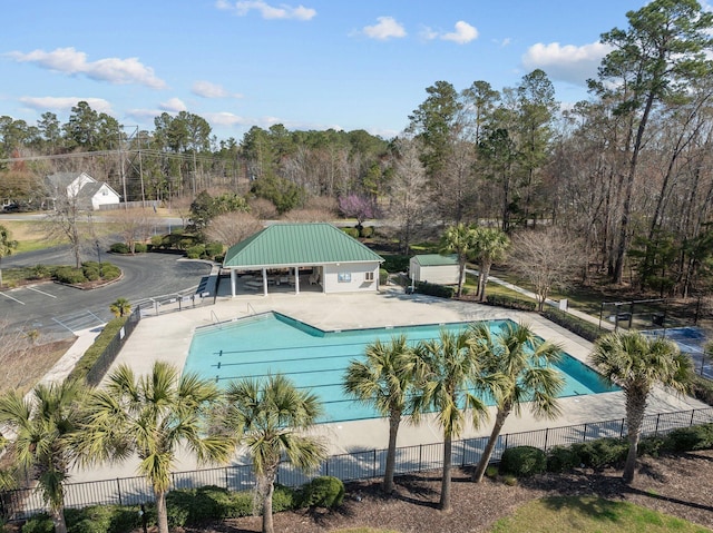 pool with a patio area and fence