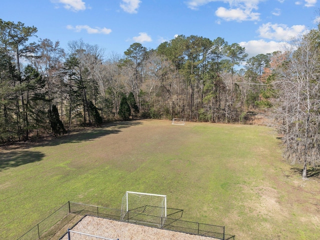 view of yard with a wooded view and fence