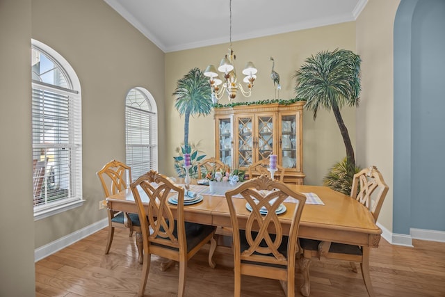 dining area with ornamental molding, arched walkways, an inviting chandelier, light wood finished floors, and baseboards