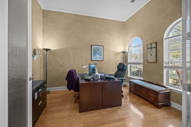 home office with light wood-style floors, baseboards, and ornamental molding