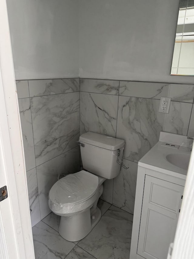 3308 Londonderry Rd, North Charleston, SC 29420 - bathroom with tile walls, vanity, marble look tile flooring, and a wainscoted wall