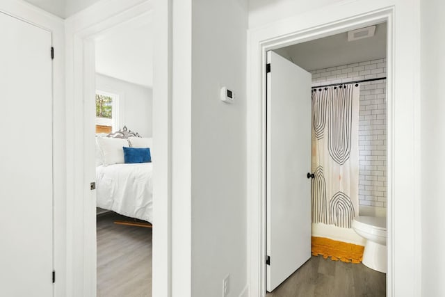 hallway with visible vents and wood finished floors