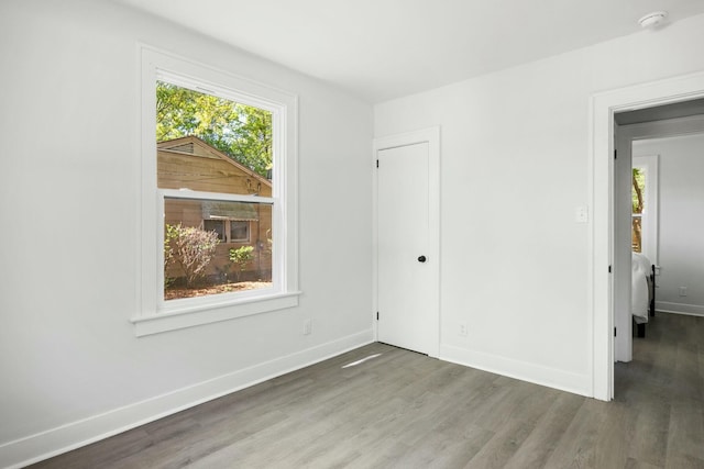 spare room featuring baseboards and wood finished floors