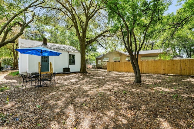 view of yard featuring central AC unit, an outdoor structure, and fence