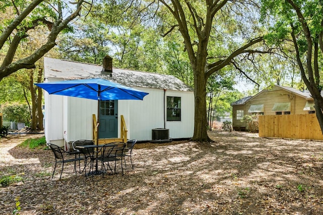 view of outbuilding featuring central AC, fence, and an outbuilding