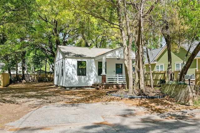 view of front of home featuring a porch and fence