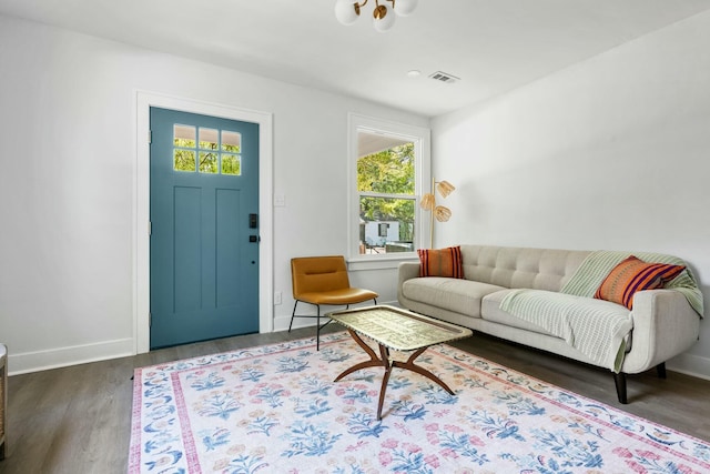 living area with wood finished floors, baseboards, and visible vents