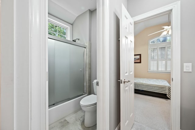 ensuite bathroom featuring shower / bath combination with glass door, connected bathroom, toilet, and lofted ceiling