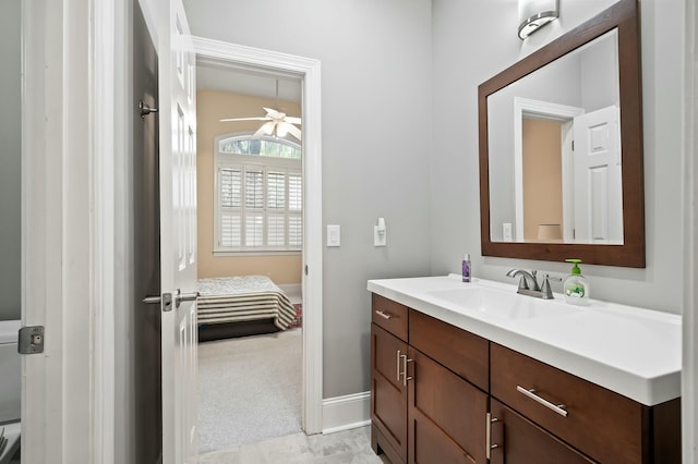 ensuite bathroom featuring baseboards, a ceiling fan, connected bathroom, and vanity