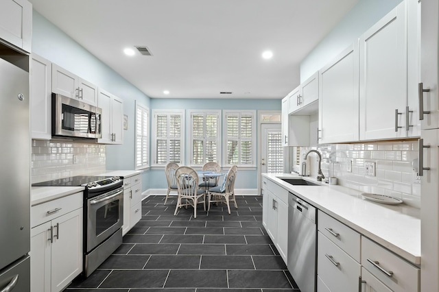 kitchen featuring visible vents, baseboards, a sink, recessed lighting, and stainless steel appliances