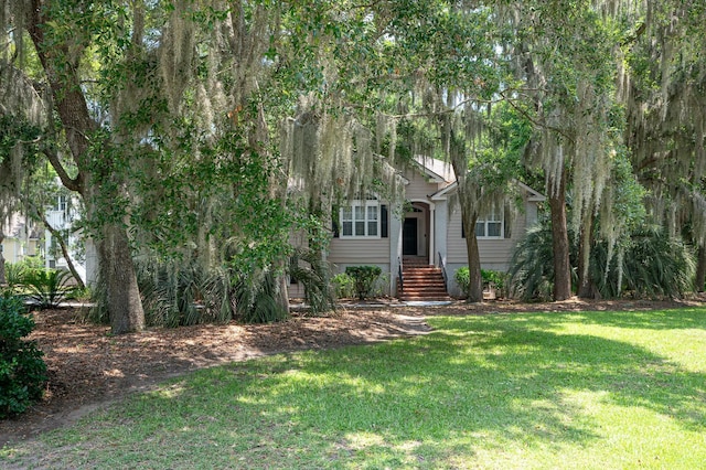 view of property hidden behind natural elements featuring a front lawn