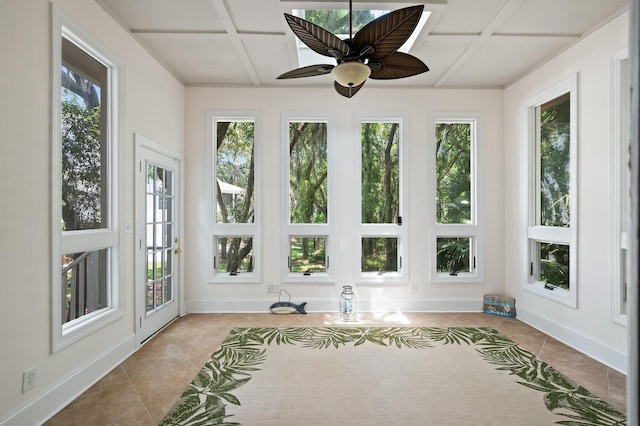 unfurnished sunroom with coffered ceiling, baseboards, and tile patterned flooring