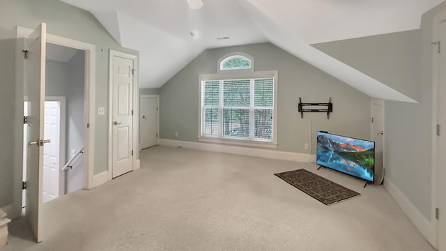 additional living space featuring carpet floors, baseboards, and lofted ceiling