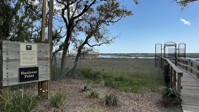 view of home's community with fence and a water view