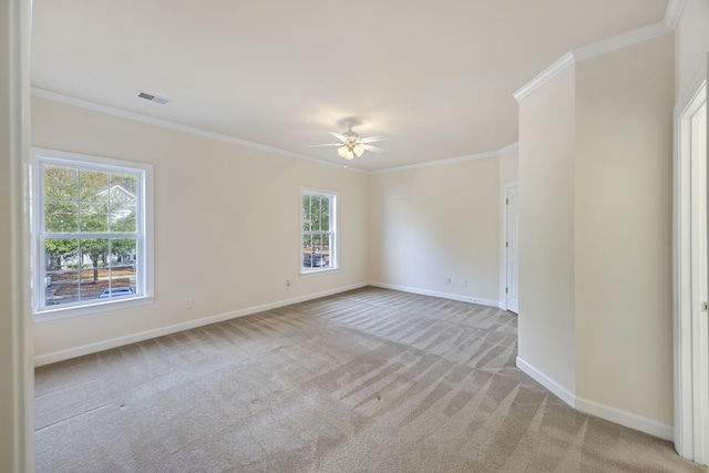 spare room with light carpet, a wealth of natural light, and crown molding