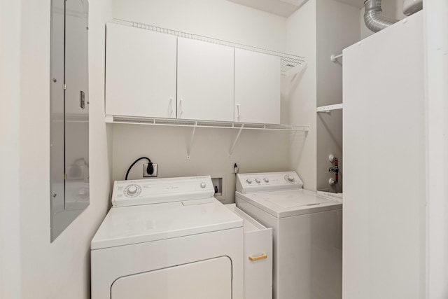 washroom featuring cabinets and separate washer and dryer