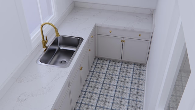 kitchen with light stone countertops and sink