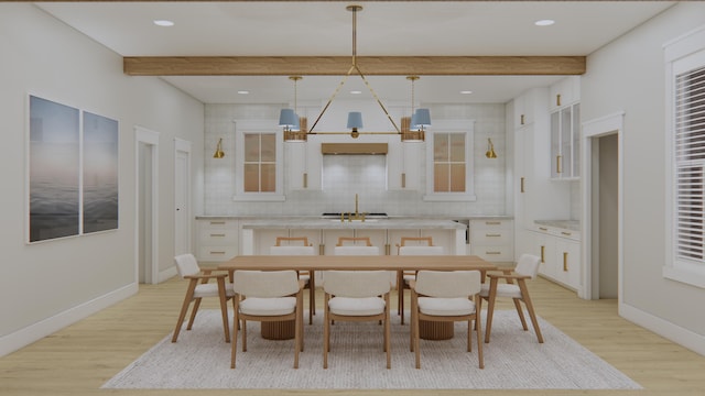 dining space with sink, beamed ceiling, a chandelier, and light hardwood / wood-style flooring