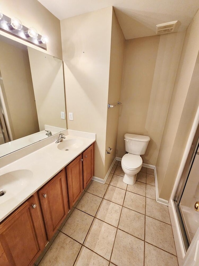 bathroom with tile patterned floors, a shower with door, vanity, and toilet