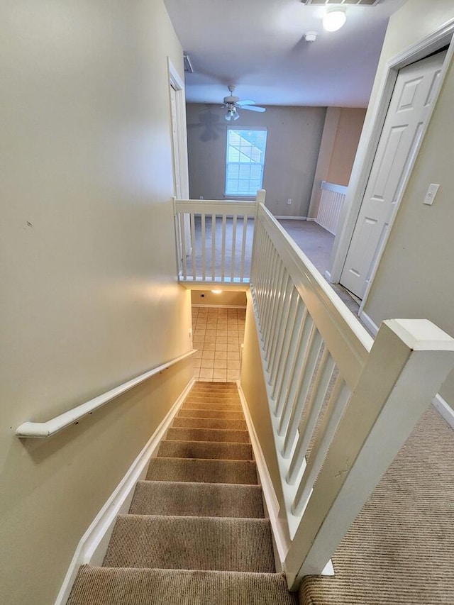 stairway with tile patterned floors and ceiling fan