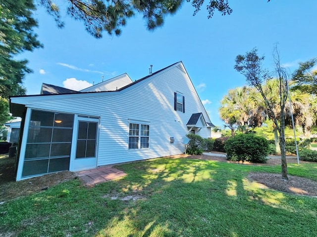 rear view of house with a sunroom and a yard