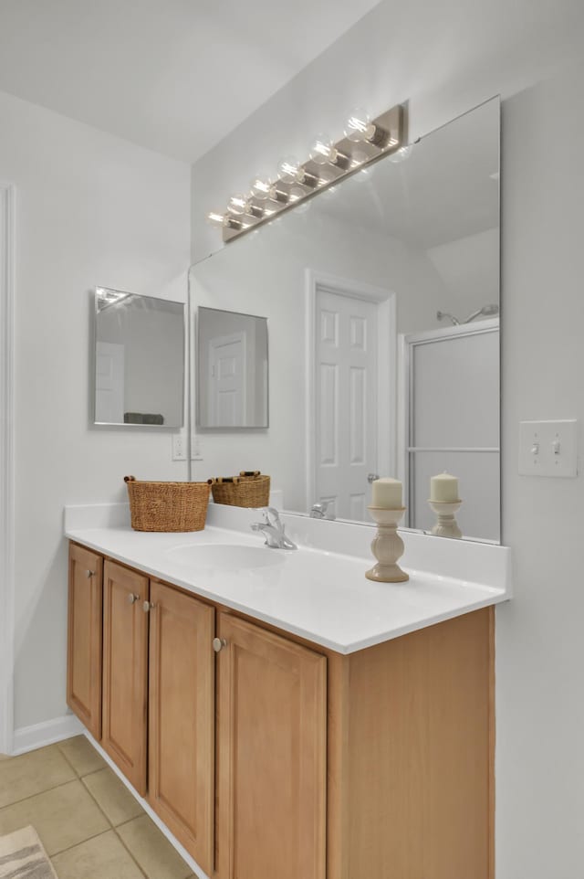 bathroom featuring tile patterned flooring, vanity, and walk in shower