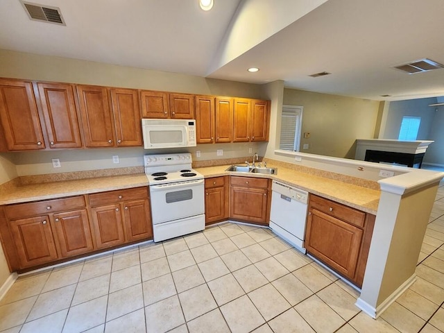 kitchen with sink, kitchen peninsula, lofted ceiling, white appliances, and light tile patterned floors