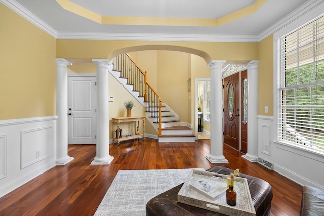 entrance foyer with dark hardwood / wood-style flooring, ornamental molding, and a raised ceiling