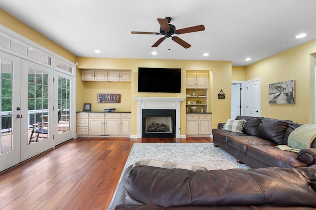 living room featuring ceiling fan, wood-type flooring, and french doors