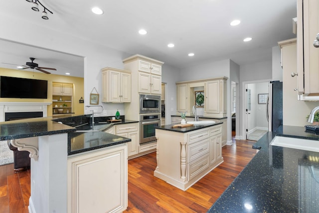 kitchen featuring hardwood / wood-style flooring, stainless steel appliances, cream cabinets, and sink