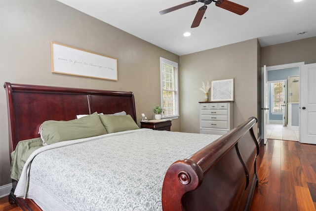 bedroom featuring dark wood-type flooring, ceiling fan, and multiple windows