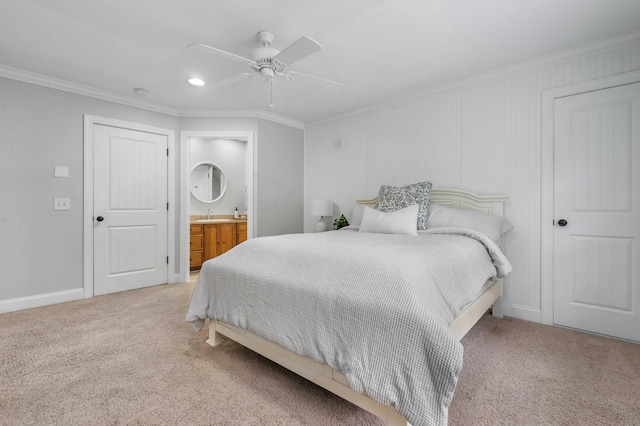 carpeted bedroom with ensuite bathroom, ceiling fan, and crown molding