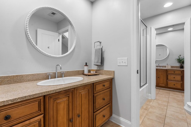 bathroom with bath / shower combo with glass door, vanity, and tile patterned floors