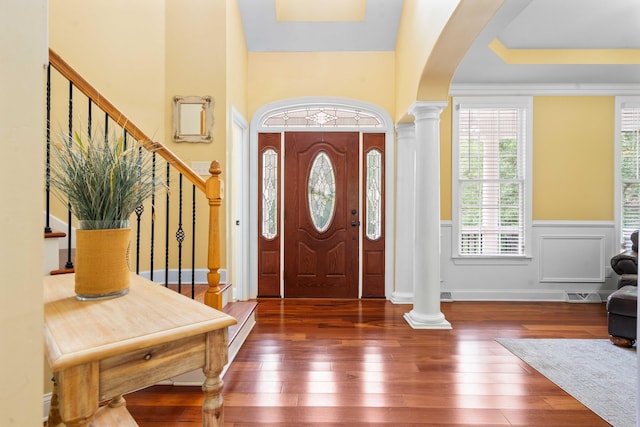 entrance foyer with ornate columns and dark hardwood / wood-style floors