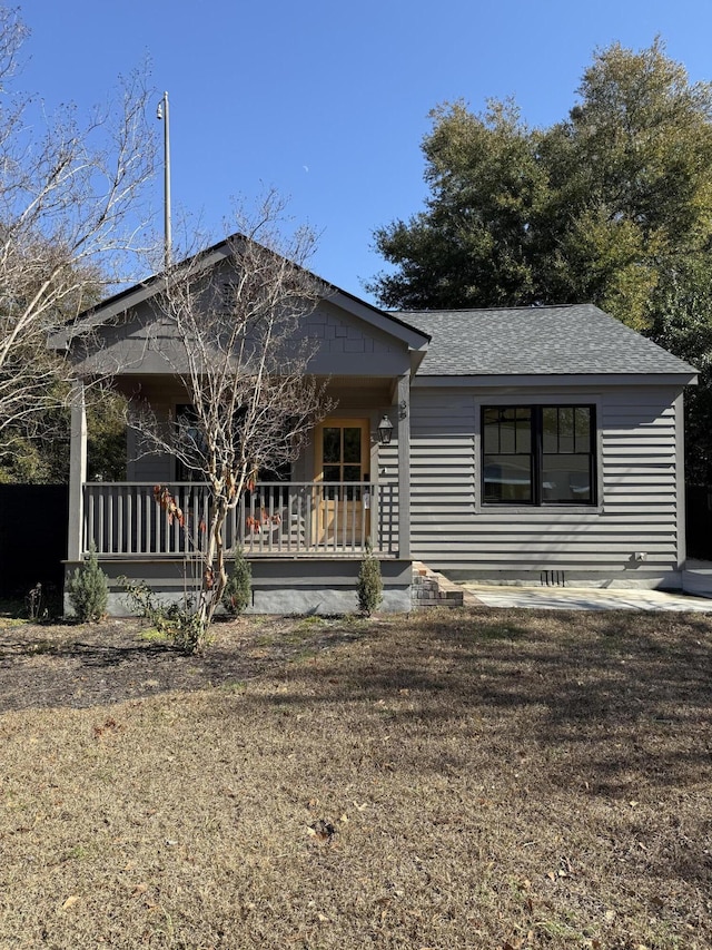 single story home with a front yard and covered porch