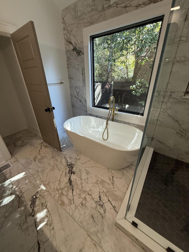 bathroom with a washtub and tile walls