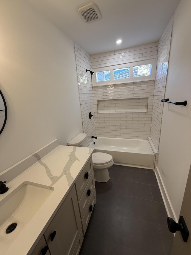 full bathroom featuring vanity, tile patterned flooring, tiled shower / bath combo, and toilet