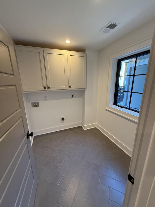 washroom featuring hookup for a washing machine, electric dryer hookup, dark hardwood / wood-style floors, and cabinets