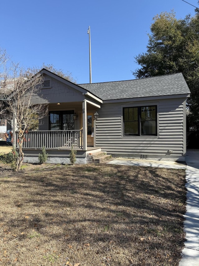 view of front of property with covered porch and a front lawn