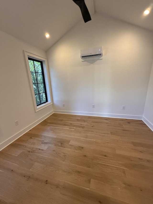 unfurnished room with wood-type flooring, a wall mounted AC, and lofted ceiling with beams