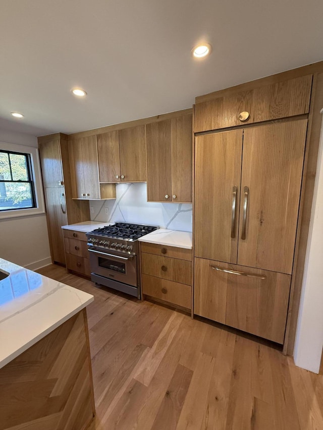 kitchen with stainless steel stove and light hardwood / wood-style flooring