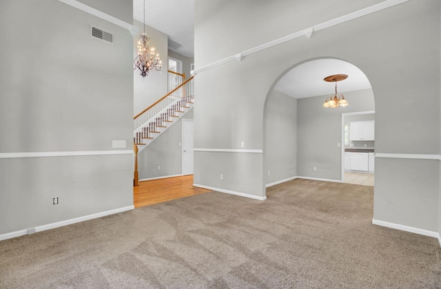 434 Antebellum Ln, Mount Pleasant, SC 29464 - carpeted empty room with a chandelier, arched walkways, a high ceiling, baseboards, and stairway