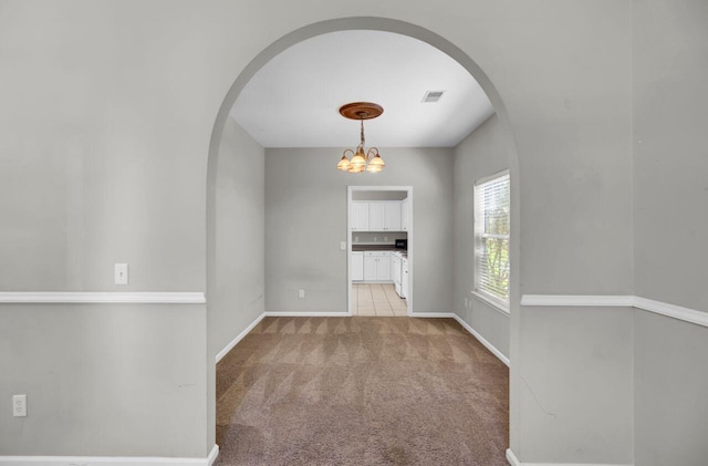 434 Antebellum Ln, Mount Pleasant, SC 29464 - empty room with arched walkways, light carpet, baseboards, and a chandelier