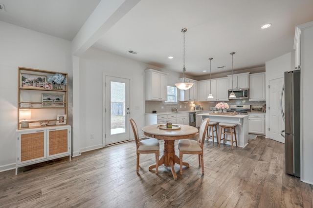 dining area featuring sink and light hardwood / wood-style floors