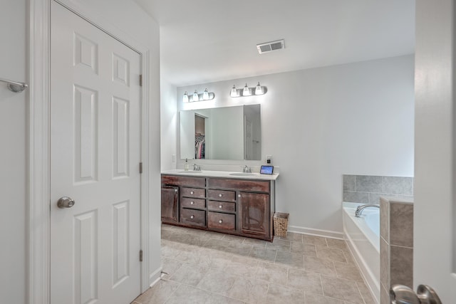 bathroom featuring vanity and tiled tub