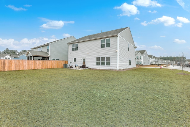 rear view of property with a yard and central AC